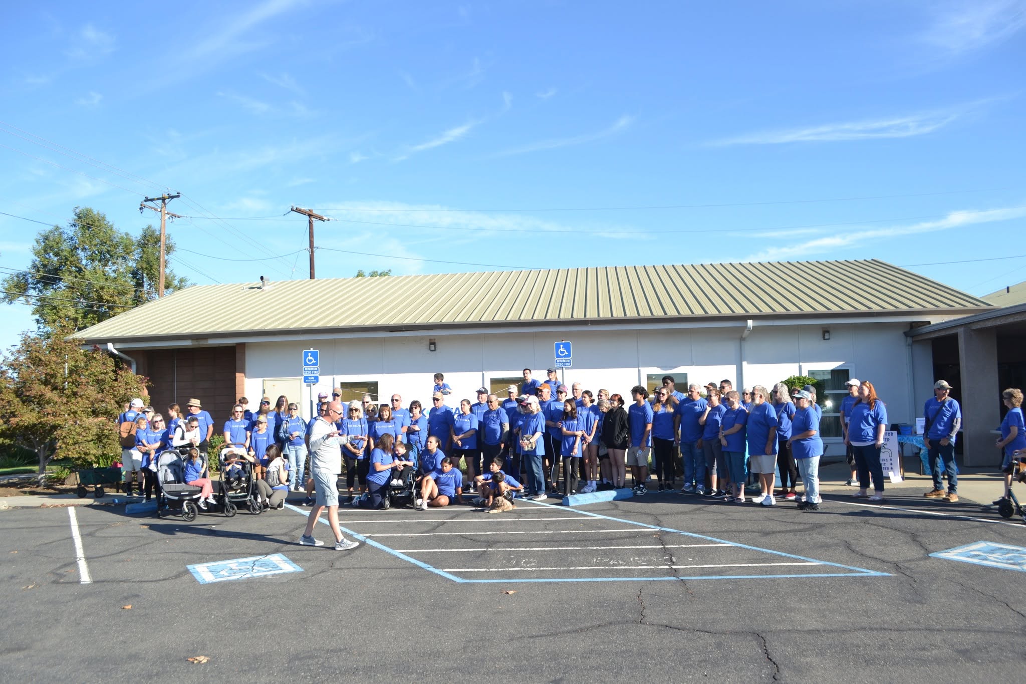 Walk4Water participants in blue shirts gathered outside the Ham Lane church building in 2025